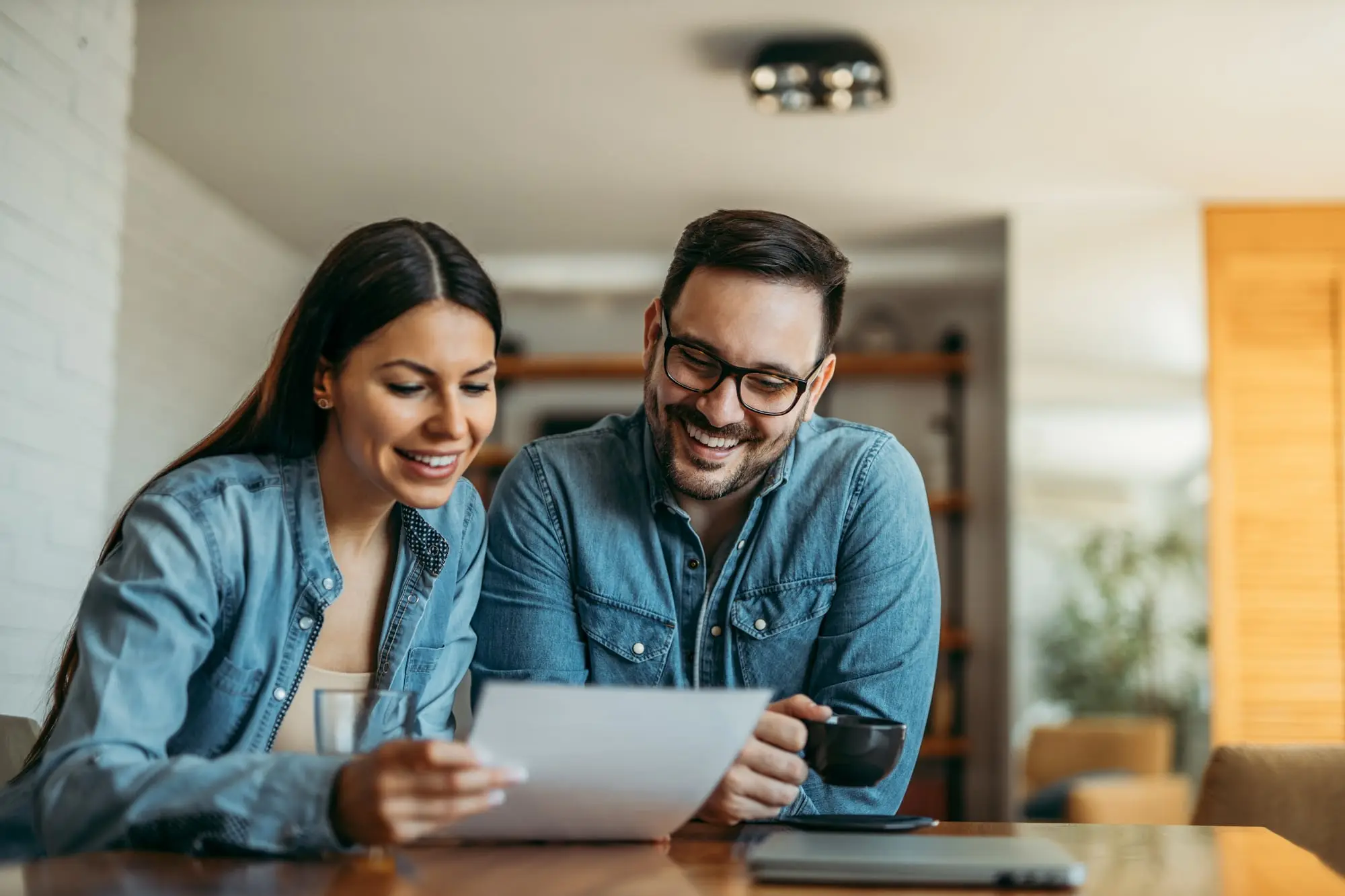 A couple at home reading a document together